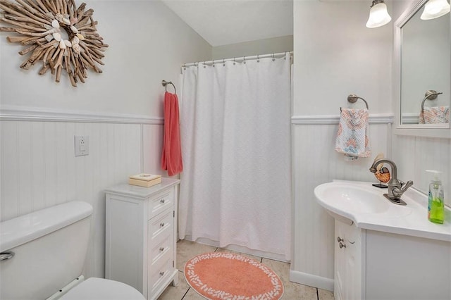 bathroom with tile patterned floors, curtained shower, vanity, and toilet