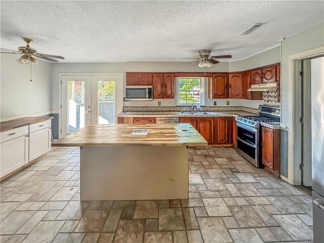 209 Lewis Dr, Rincon, GA 31326 - kitchen with stainless steel appliances, ceiling fan, under cabinet range hood, butcher block counters, and a textured ceiling