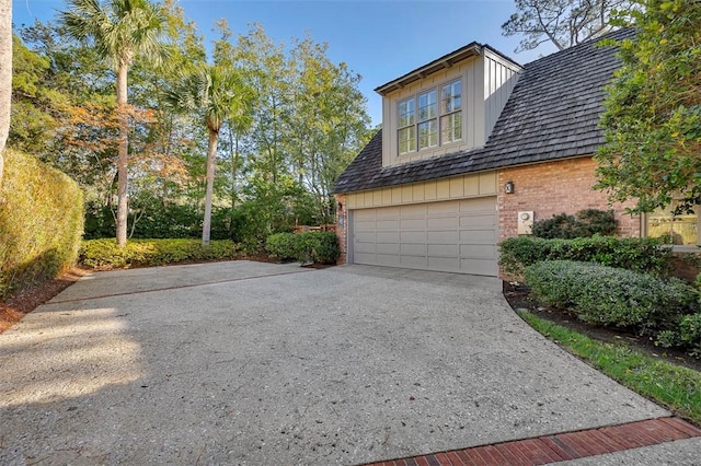 view of home's exterior featuring concrete driveway and brick siding