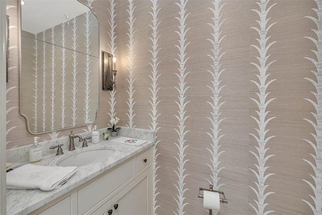 bathroom featuring vanity and wallpapered walls