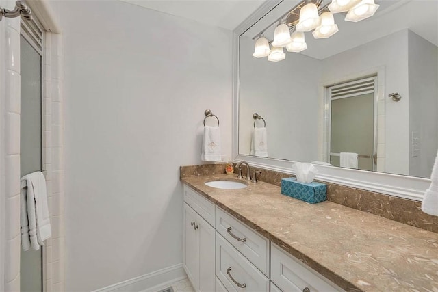 bathroom featuring an inviting chandelier, baseboards, and vanity