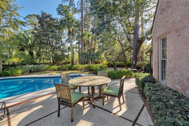 outdoor pool with a patio area and outdoor dining space