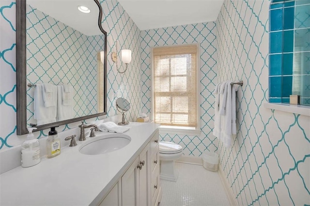 bathroom with toilet, wallpapered walls, tile patterned flooring, and vanity