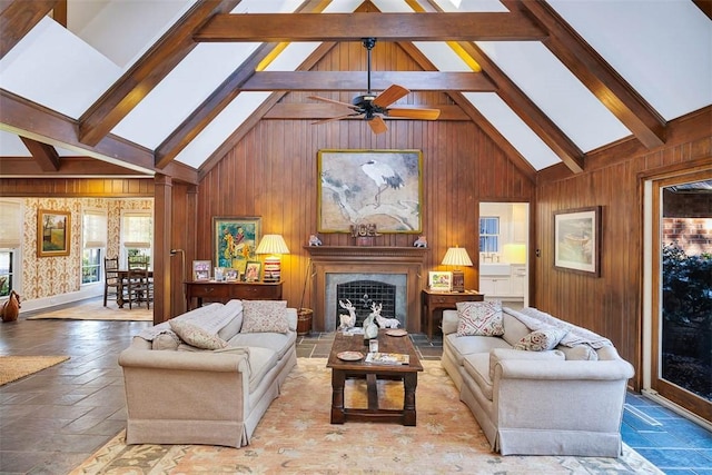 living area featuring a skylight, beam ceiling, stone tile flooring, a high end fireplace, and high vaulted ceiling