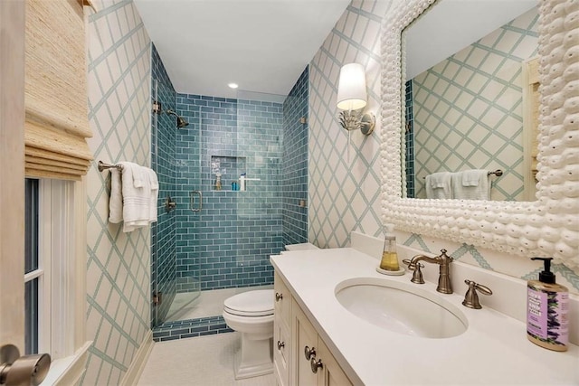 bathroom featuring a stall shower, toilet, tile patterned floors, vanity, and tile walls