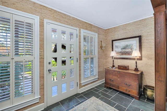 foyer entrance featuring a healthy amount of sunlight, baseboards, and crown molding