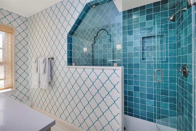 bathroom with wallpapered walls and walk in shower