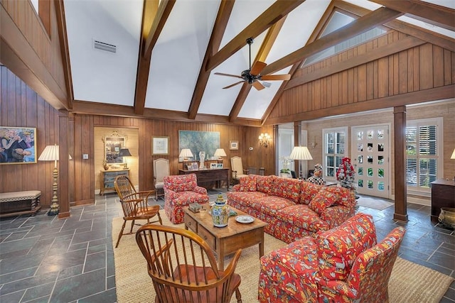 living area featuring visible vents, wood walls, a skylight, and stone tile flooring