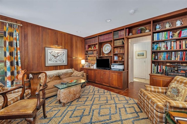 living area with wood walls and wood finished floors