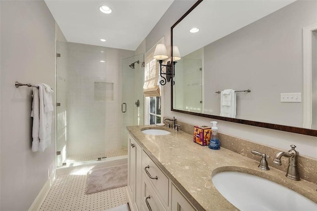 bathroom featuring double vanity, a stall shower, a sink, and recessed lighting