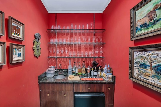 bar featuring ornamental molding, wet bar, and a sink