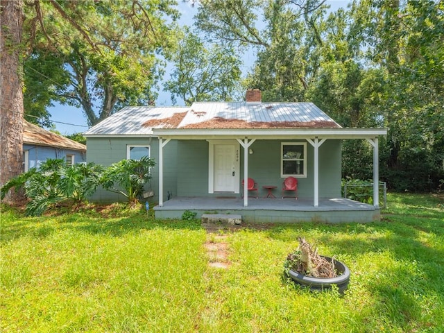 rear view of house with a porch and a lawn