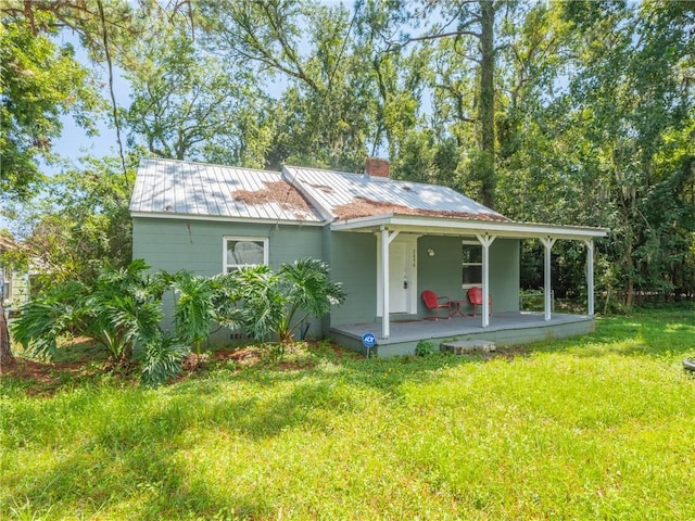 back of property with a porch and a yard