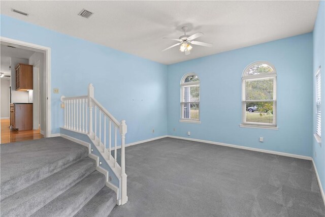 carpeted spare room featuring ceiling fan