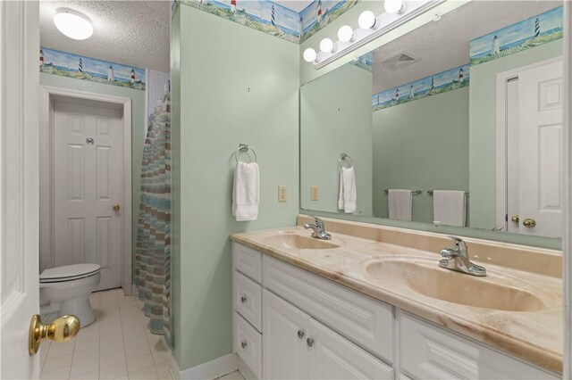 bathroom with vanity, tile patterned floors, a shower with shower curtain, toilet, and a textured ceiling