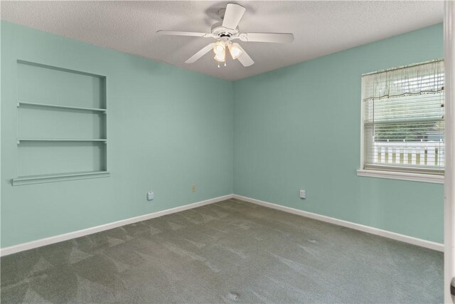 carpeted spare room featuring a textured ceiling and ceiling fan