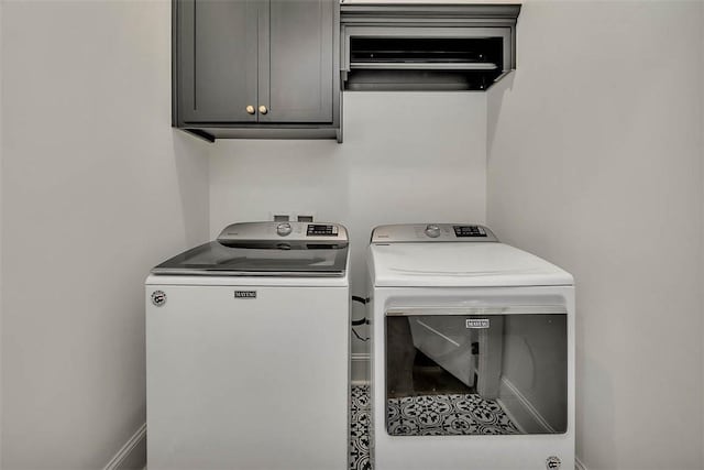 laundry room with cabinets and washing machine and clothes dryer