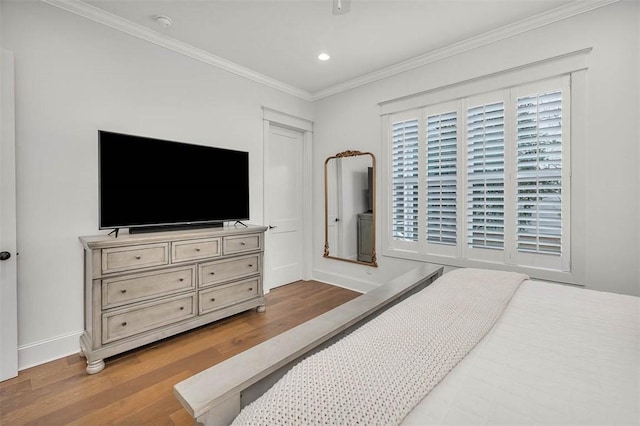 bedroom featuring ornamental molding and light wood-type flooring