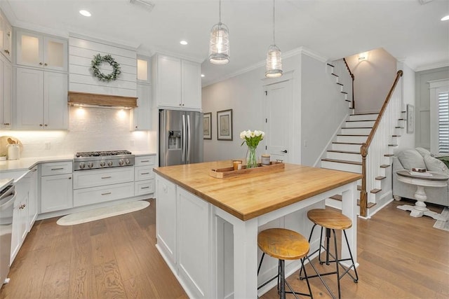 kitchen with white cabinets, a center island, stainless steel appliances, and backsplash