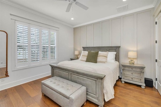 bedroom with light wood-type flooring, ceiling fan, and crown molding