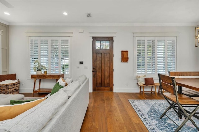 entryway featuring wood-type flooring and ornamental molding