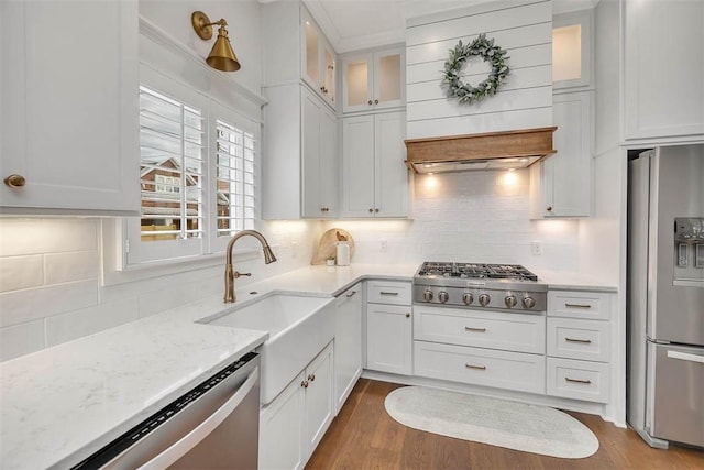 kitchen featuring white cabinetry, sink, stainless steel appliances, hardwood / wood-style floors, and decorative backsplash