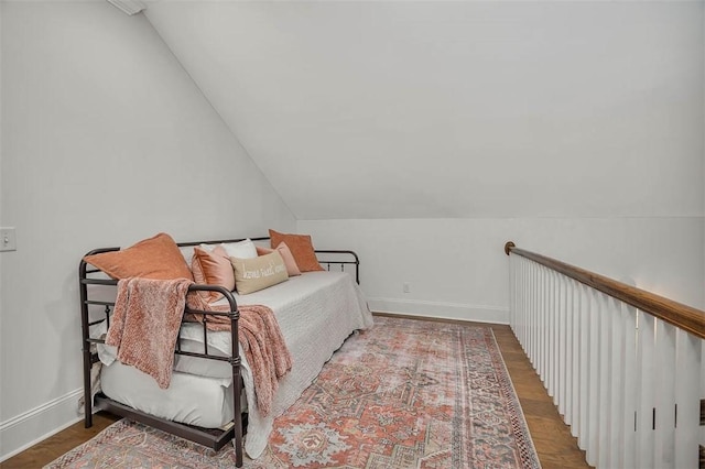 bedroom with hardwood / wood-style floors and lofted ceiling