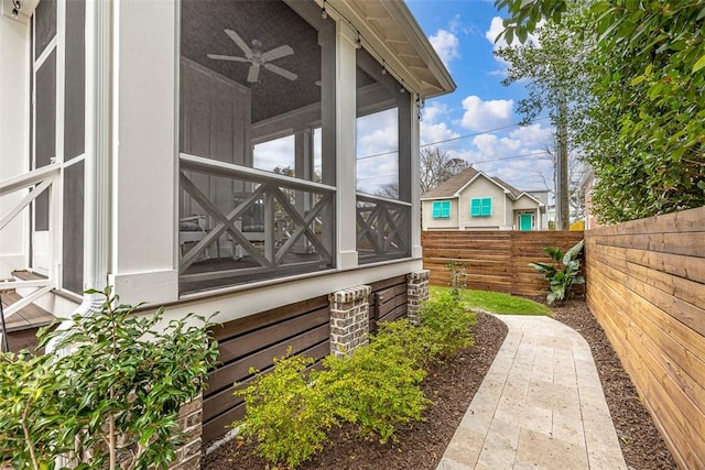 view of property exterior featuring a sunroom and ceiling fan