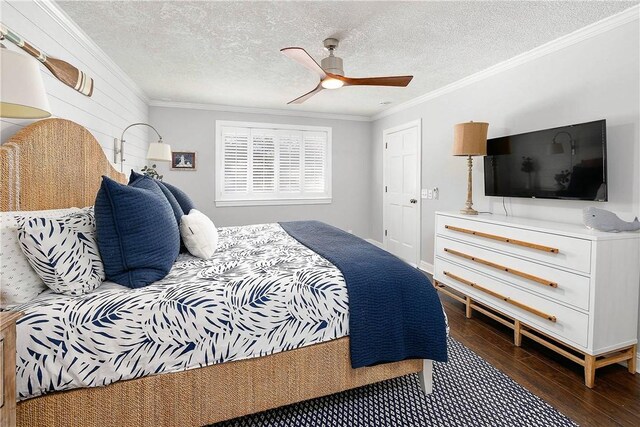bedroom with a textured ceiling, dark hardwood / wood-style floors, ceiling fan, and crown molding