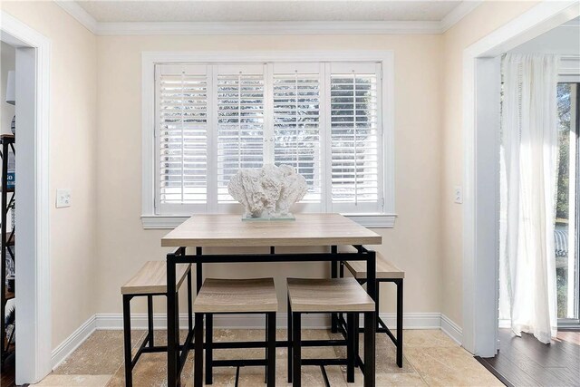 dining room featuring a wealth of natural light, ornamental molding, and light wood-type flooring
