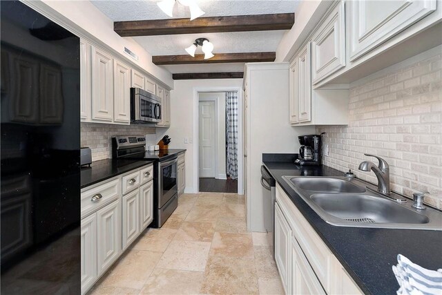 kitchen with sink, appliances with stainless steel finishes, tasteful backsplash, beam ceiling, and white cabinetry