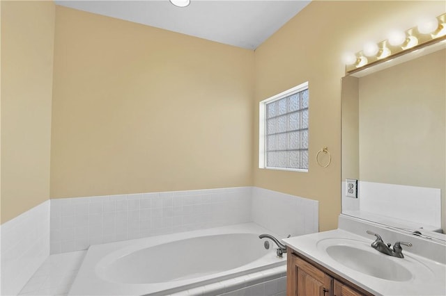 bathroom featuring vanity and tiled bath