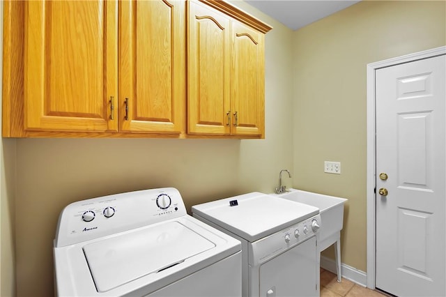 laundry area with cabinets, light tile patterned flooring, and washing machine and dryer