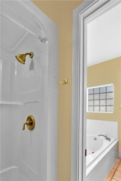 bathroom with a relaxing tiled tub and tile patterned floors