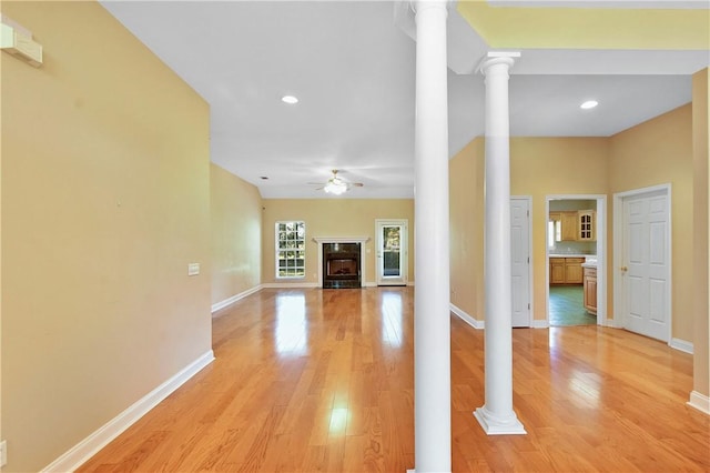 unfurnished living room with ceiling fan, light hardwood / wood-style floors, and decorative columns