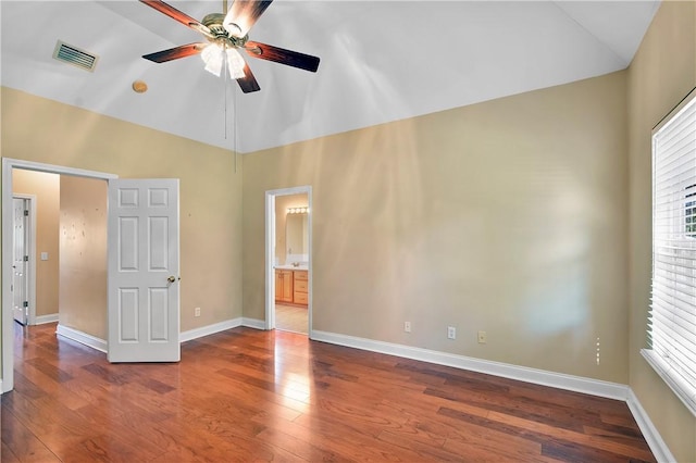 unfurnished bedroom featuring connected bathroom, ceiling fan, hardwood / wood-style floors, and high vaulted ceiling