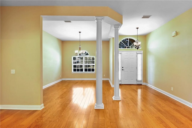 entryway with wood-type flooring and a notable chandelier