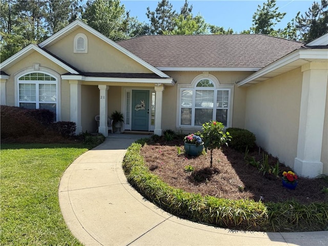 21 Fernleaf Ct, Brunswick, GA 31525 - view of front of house featuring stucco siding, roof with shingles, and a front lawn