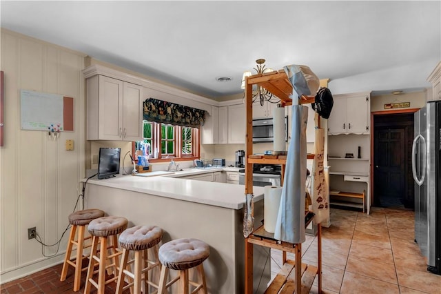 1001 Coral Rd, Waycross, GA 31501 - kitchen featuring appliances with stainless steel finishes, a peninsula, light countertops, and a kitchen breakfast bar