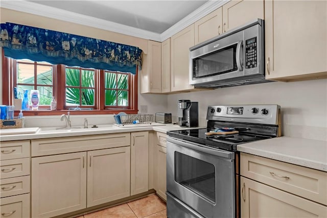 1001 Coral Rd, Waycross, GA 31501 - kitchen with appliances with stainless steel finishes, a sink, light countertops, light tile patterned flooring, and cream cabinetry