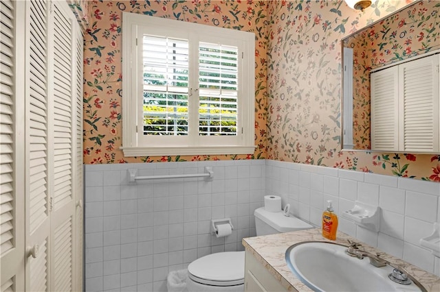 1001 Coral Rd, Waycross, GA 31501 - half bath with a closet, wallpapered walls, vanity, toilet, and a wainscoted wall