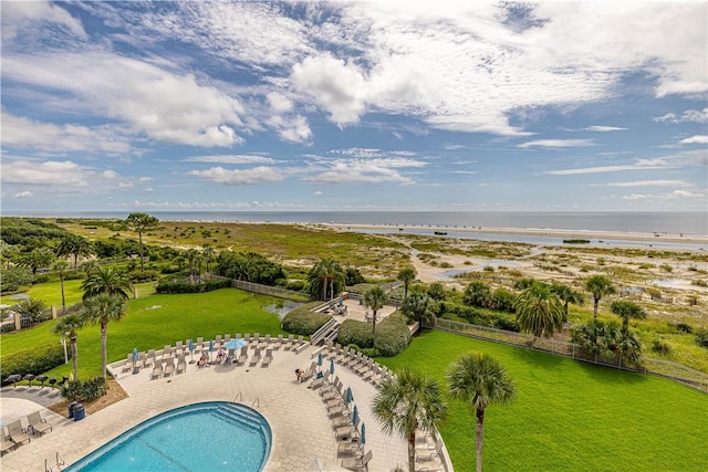 community pool with a water view, fence, and a patio area