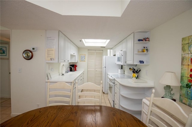 kitchen featuring white appliances, light tile patterned floors, open shelves, a skylight, and light countertops