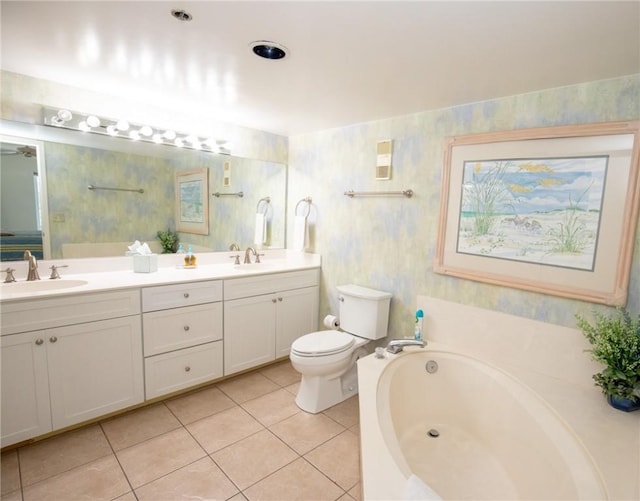 bathroom featuring tile patterned floors, toilet, a garden tub, and a sink