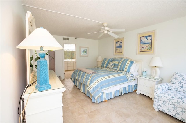 bedroom featuring visible vents, a textured ceiling, ensuite bath, and a ceiling fan