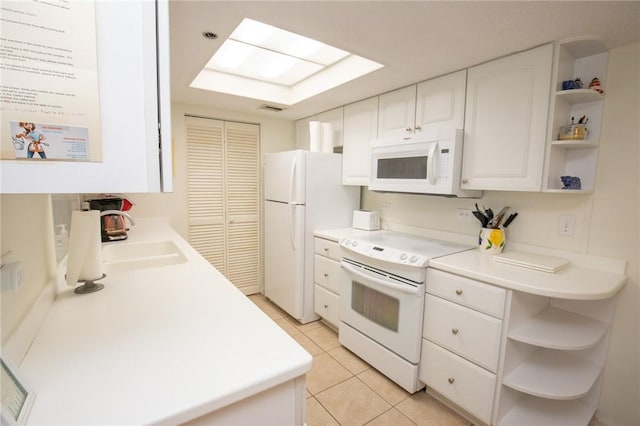 kitchen featuring white appliances, light tile patterned floors, open shelves, a sink, and white cabinets