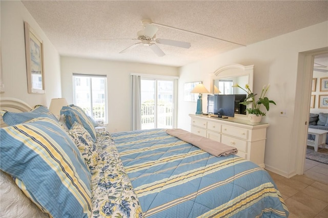 bedroom with tile patterned floors, baseboards, a textured ceiling, and a ceiling fan