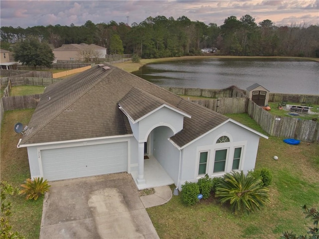 view of front of house with a water view, a garage, and a yard