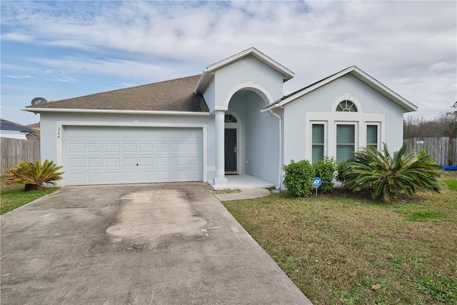 ranch-style home featuring a garage and a front lawn