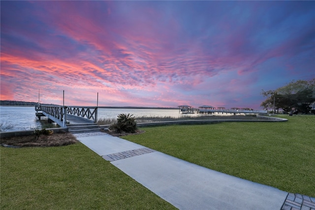 surrounding community featuring a water view and a lawn